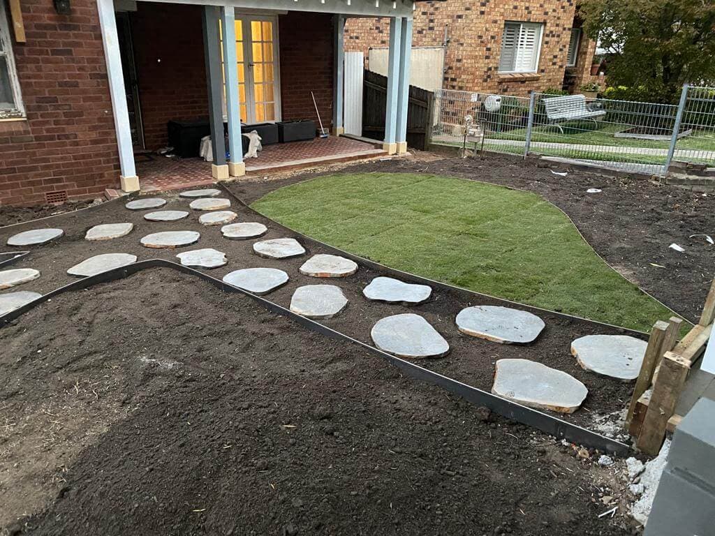 Fresh planting and mulched beds beside the new lawn