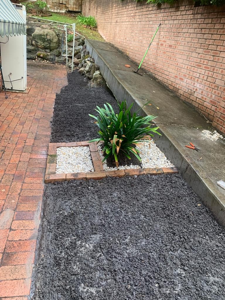 Fresh turf and pebble garden bed taking shape
