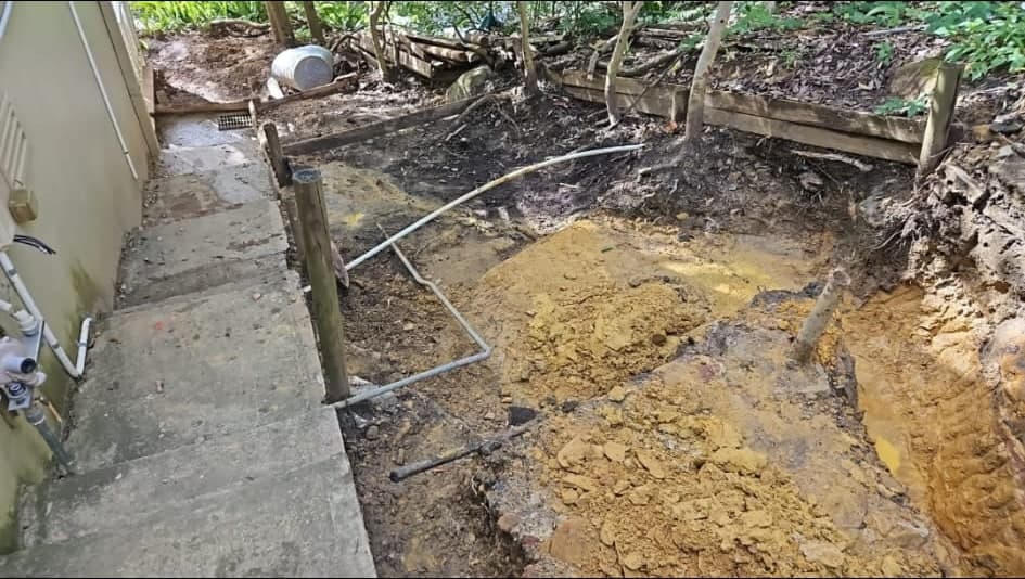 Failing timber retaining and unstable garden edge before removal