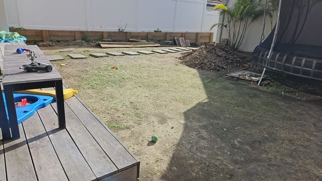 Paved path construction underway through the garden