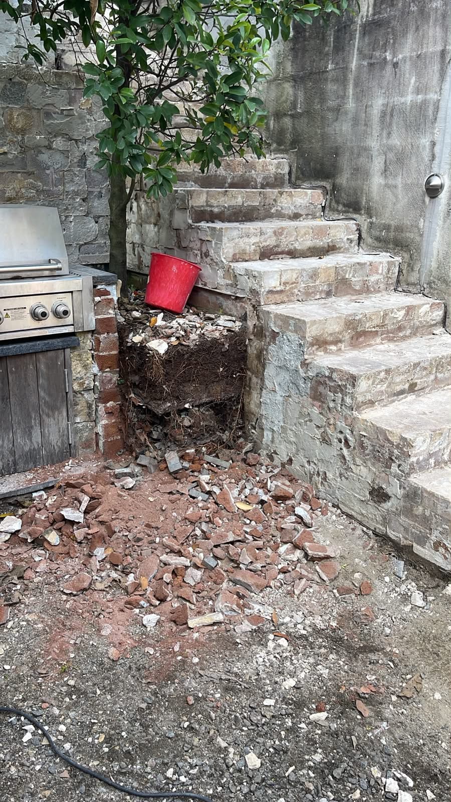 Old paving and cladding removed around the courtyard steps