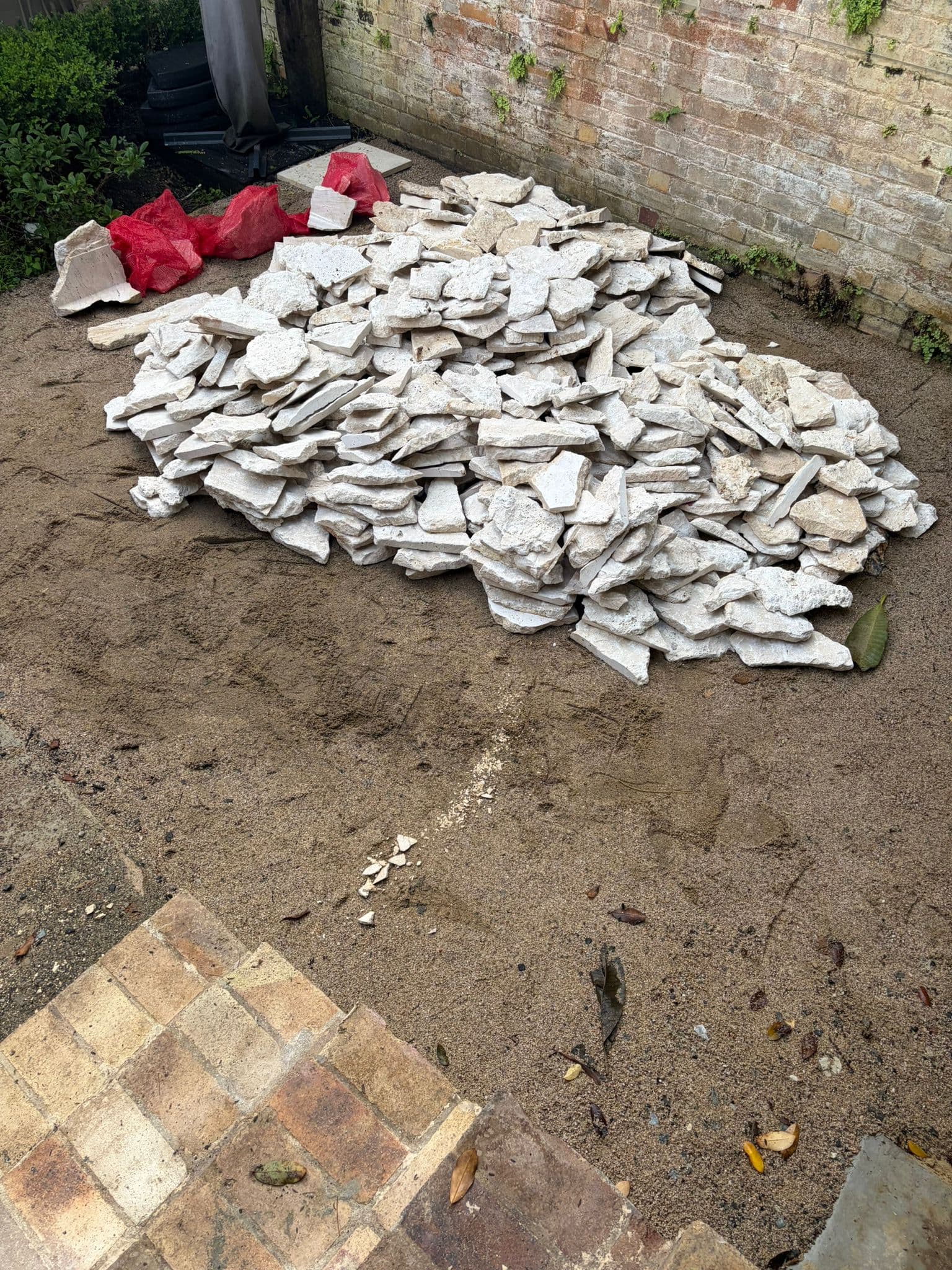 Removed retaining-wall cladding stacked in the courtyard