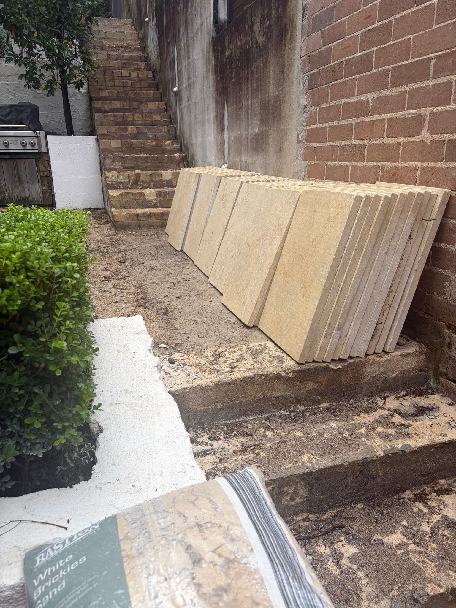 Replacement pavers staged beside the side passage